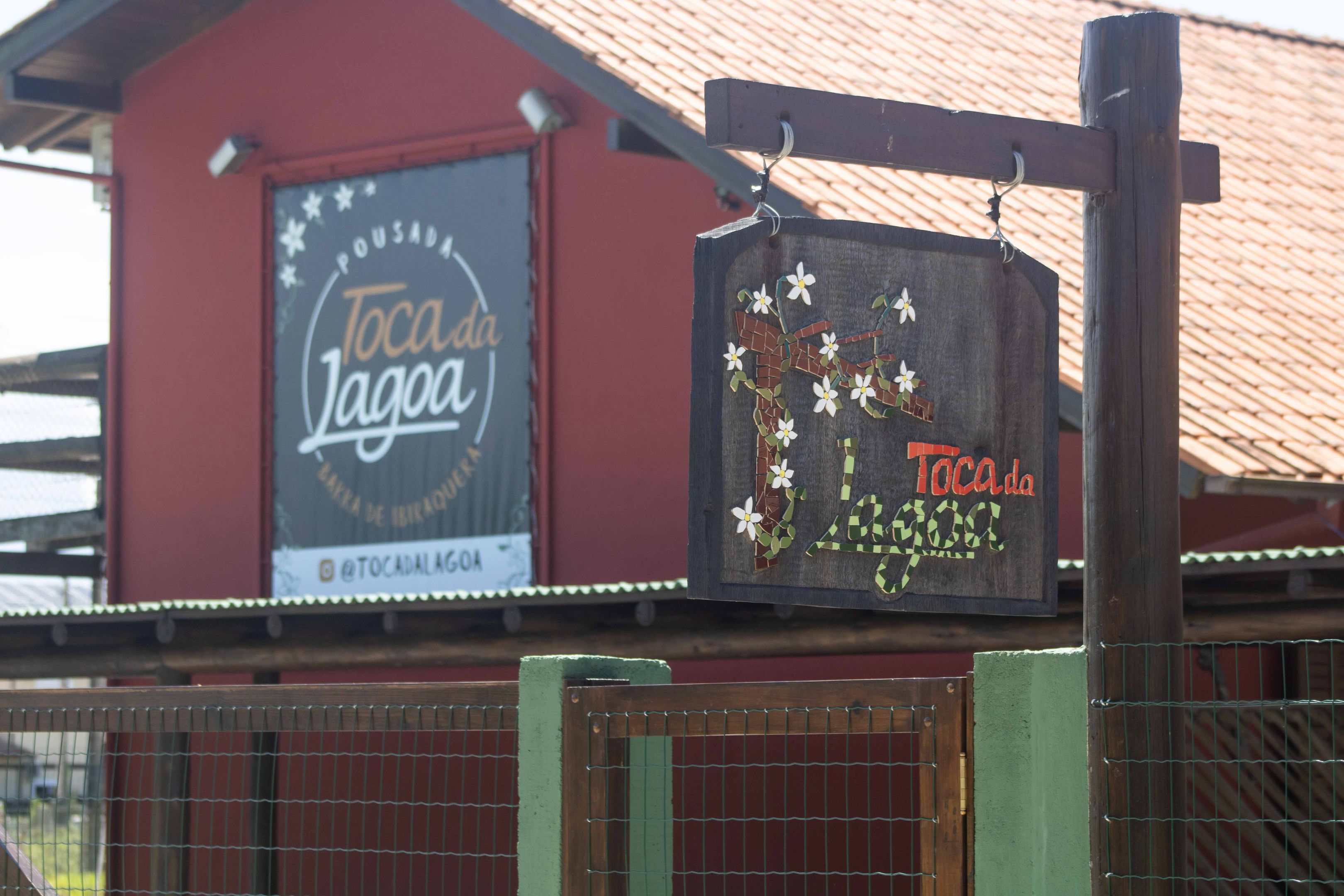 Placa rústica da Pousada Toca da Lagoa